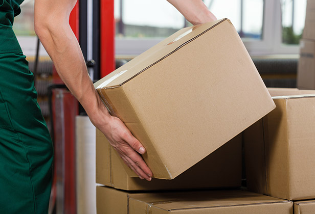 Man in green overalls stacking boxes